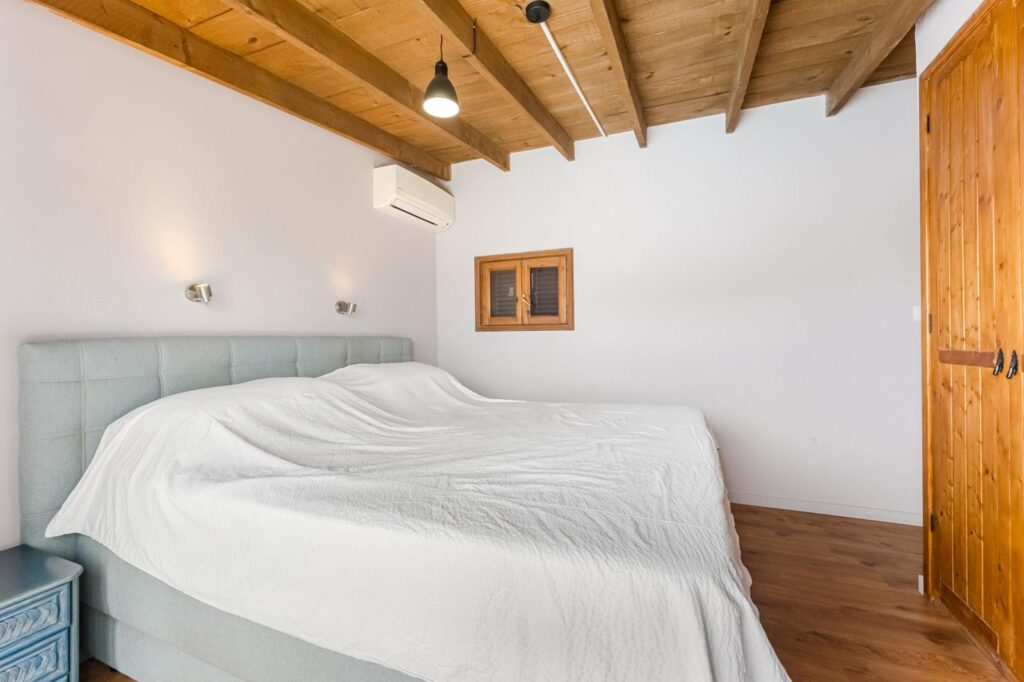 Dormitorio de matrimonio con pequeña ventana de madera